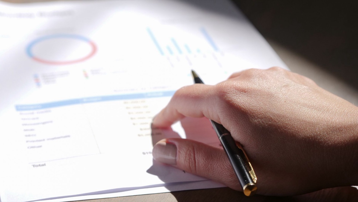 A person reviews financial documents on a desk